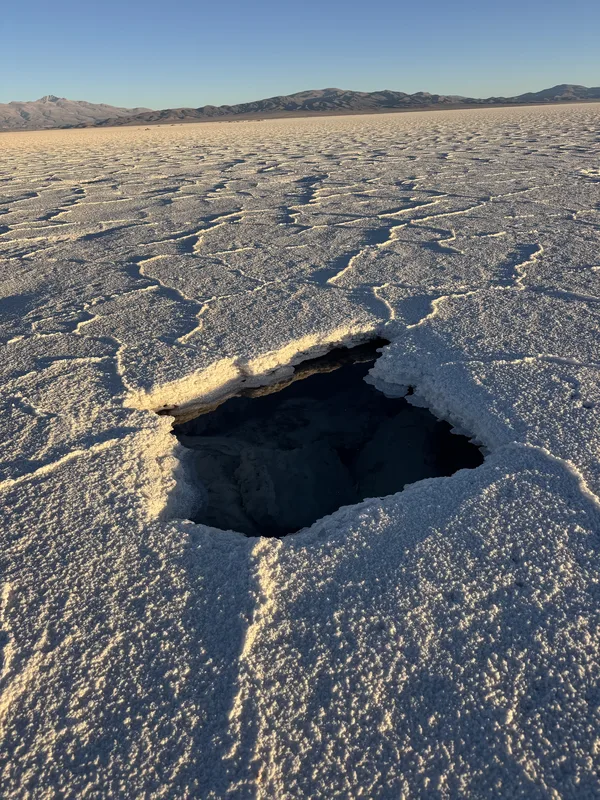 A collapsed void in the salt crust of what appears to be the Salar de Arizaro or a comparable Andean salt flat in Argent