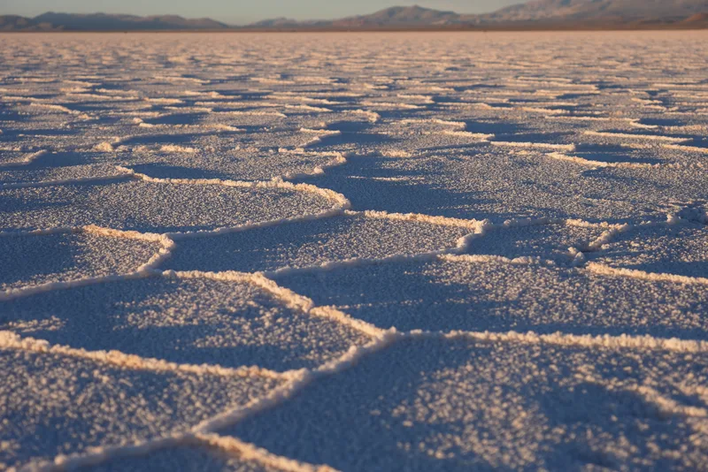 The salt flat surface of what appears to be the Salar de Uyuni in Bolivia, or a comparable high-altitude salt lake, phot