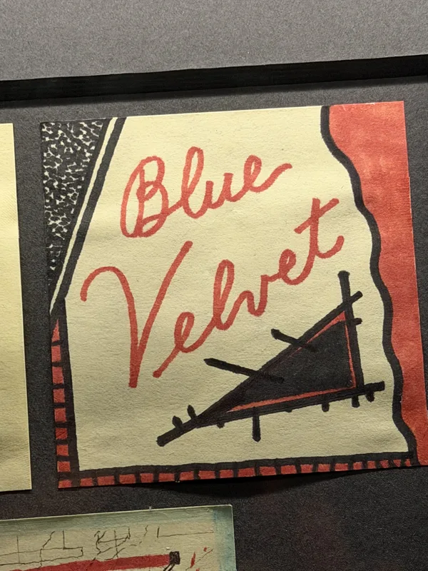 'Blue Velvet' in red cursive. The object carries weight the photograph admits it cannot lift.