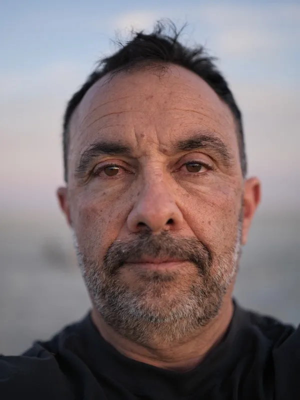 A middle-aged man of likely Mediterranean or Middle Eastern descent, approximately 45-55 years of age, with salt-and-pep