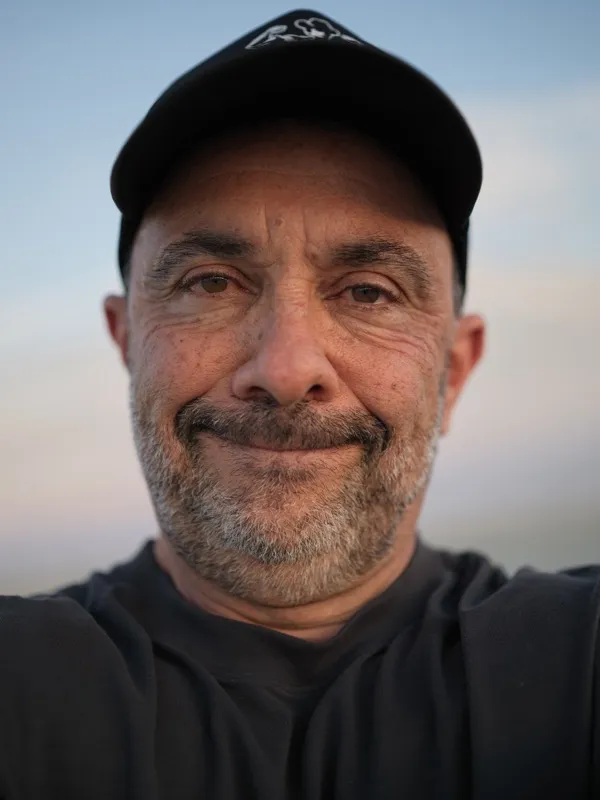A middle-aged man, photographed at close range, looking directly into the camera with a relaxed, open expression.