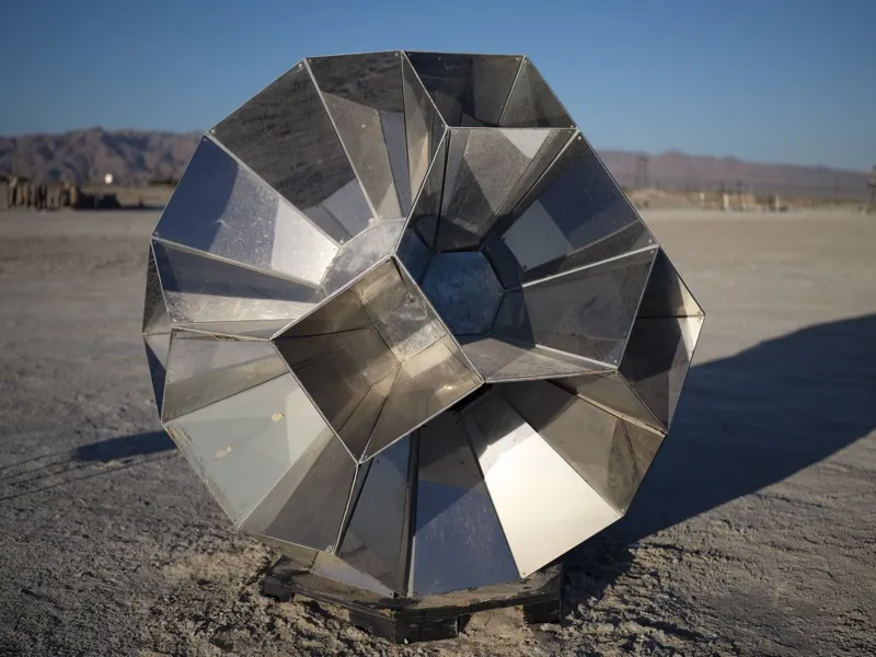 A large-scale fabricated metal sculpture of spiral-logarithmic form, constructed from polished galvanized steel panels a