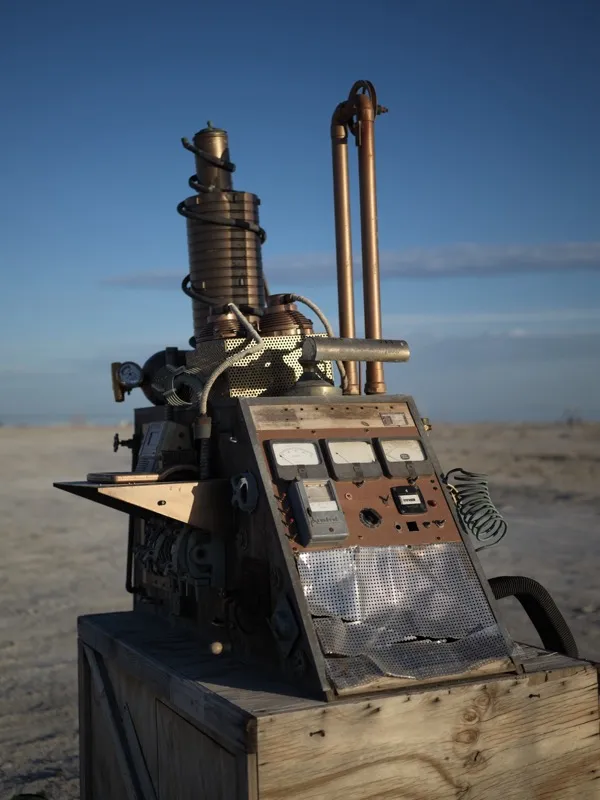 A handmade, assemblage-style machine built from salvaged industrial and domestic components — gauges, copper pipe, coile